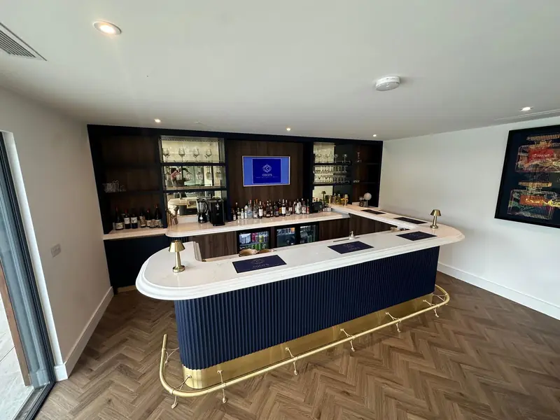 Bar area with herringbone floor and back-lit shelving