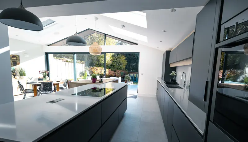 Kitchen island with dark cabinets under a vaulted ceiling