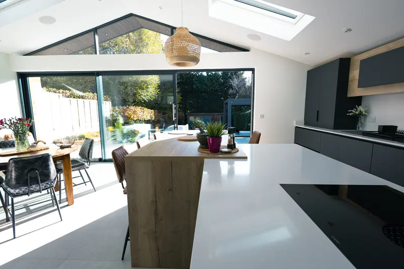 Oak breakfast bar joining the island, with the garden beyond