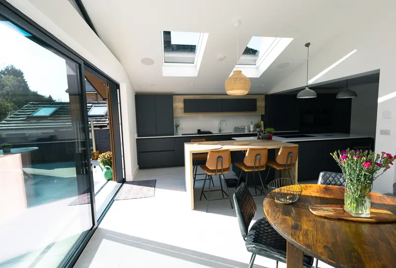 Open-plan kitchen and dining area with roof windows and full-width sliding doors