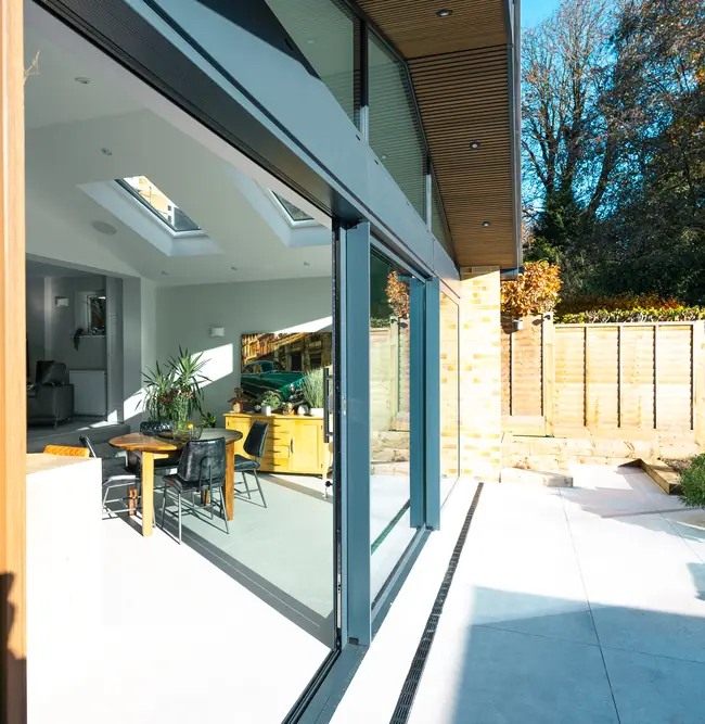 Outside view of the extension's sliding doors, timber soffit and patio